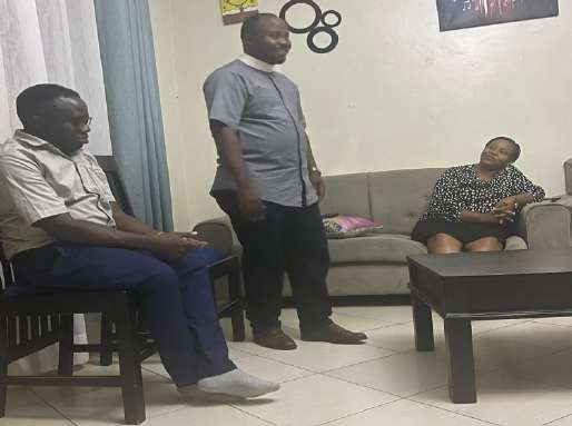 A man speaking to members seated in a living room during home-cell fellowship